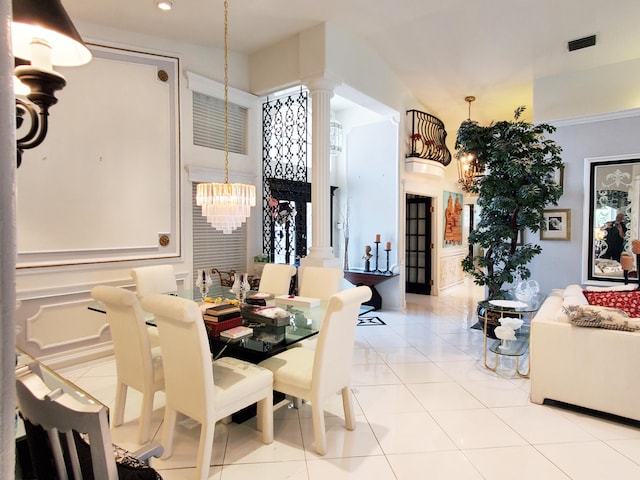 tiled dining area with decorative columns and an inviting chandelier