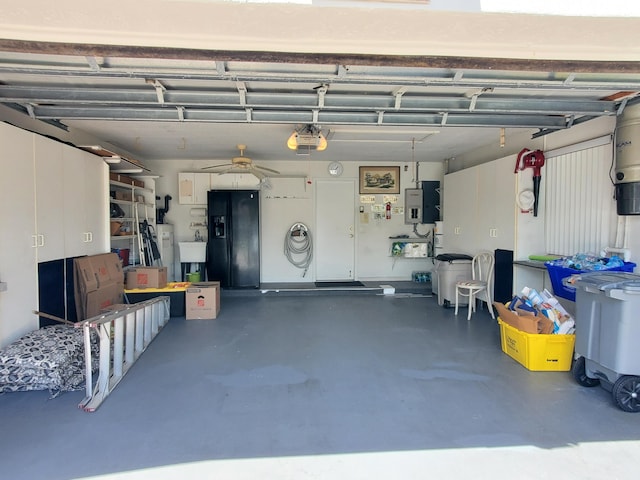 garage with electric panel, ceiling fan, sink, and black fridge with ice dispenser