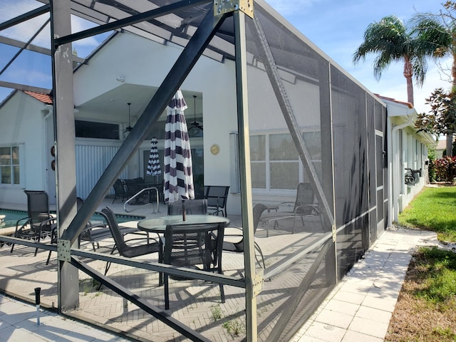 view of patio featuring glass enclosure