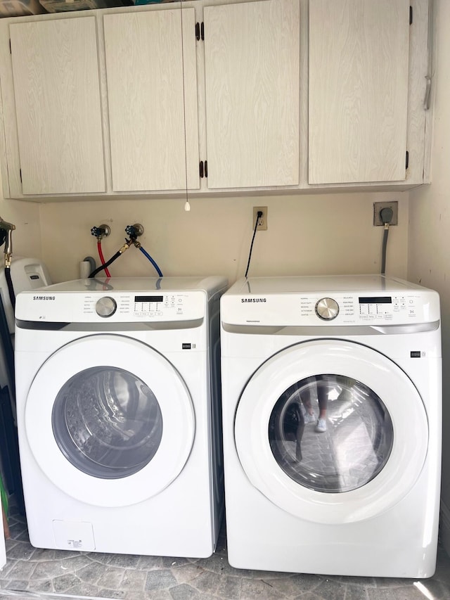 washroom with cabinets and washer and clothes dryer