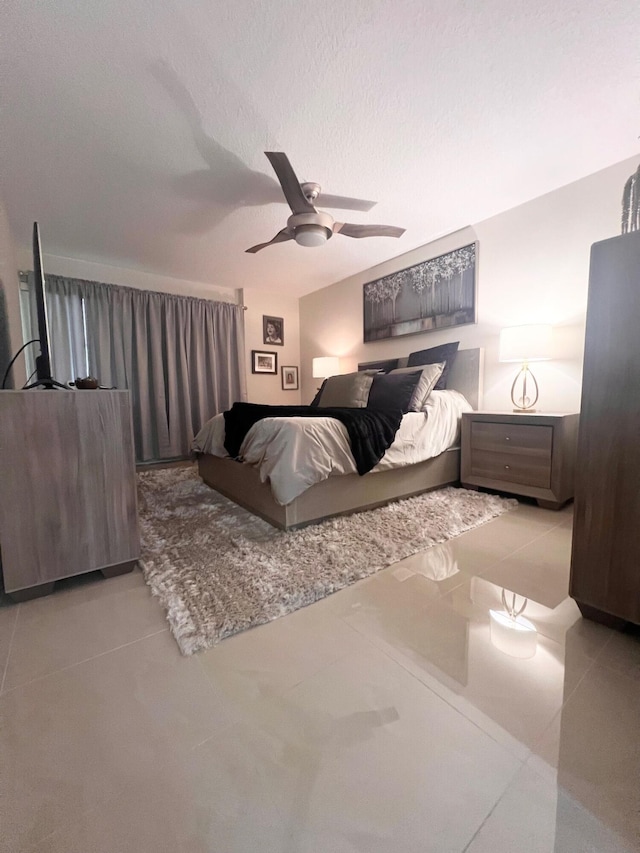 bedroom with light tile patterned flooring, ceiling fan, and a textured ceiling