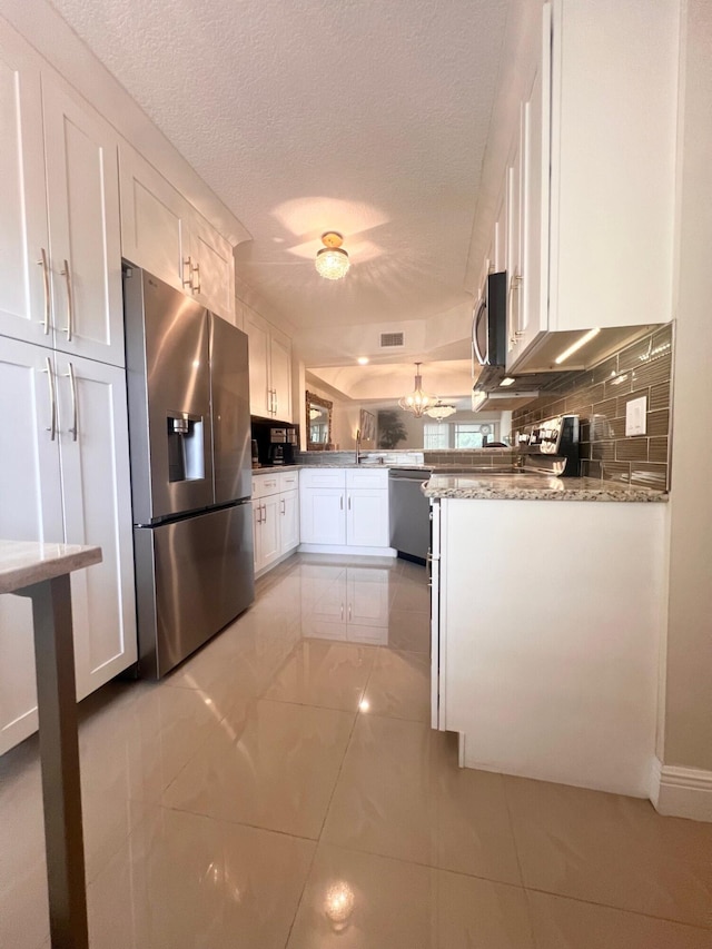 kitchen featuring white cabinets, a textured ceiling, appliances with stainless steel finishes, and decorative backsplash