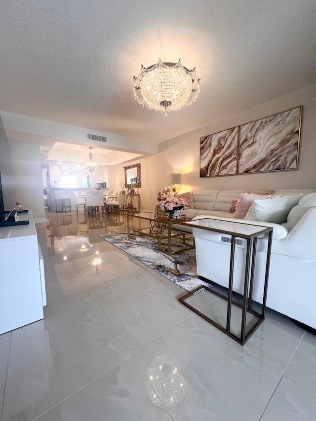 unfurnished living room featuring a textured ceiling and a chandelier