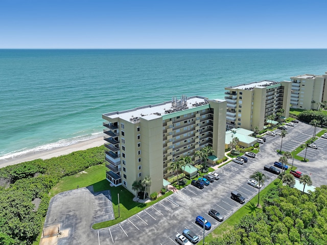 birds eye view of property featuring a water view and a beach view