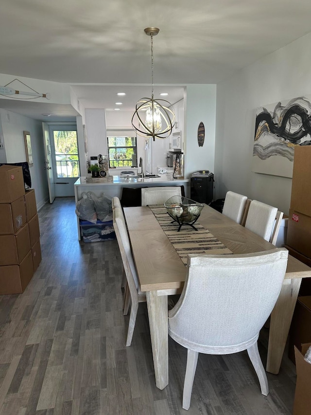 dining area with an inviting chandelier, dark hardwood / wood-style floors, and sink