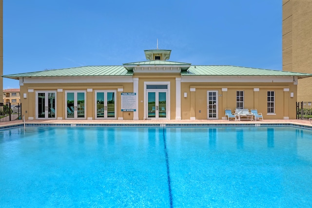 view of swimming pool featuring french doors and a patio