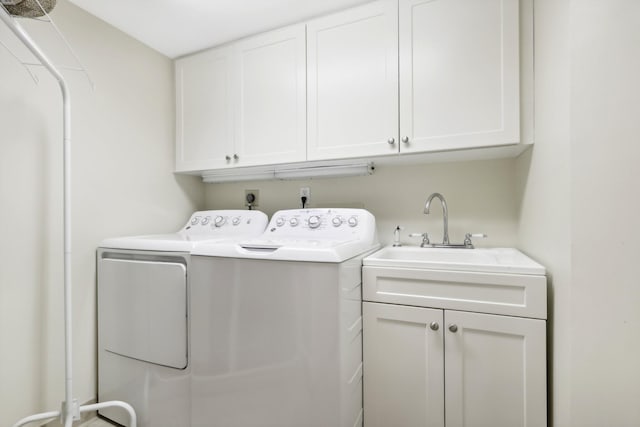 washroom featuring cabinets, independent washer and dryer, and sink