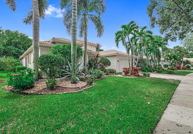 mediterranean / spanish-style house with a garage and a front lawn