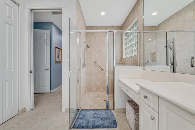 bathroom with walk in shower, vanity, and tile patterned floors