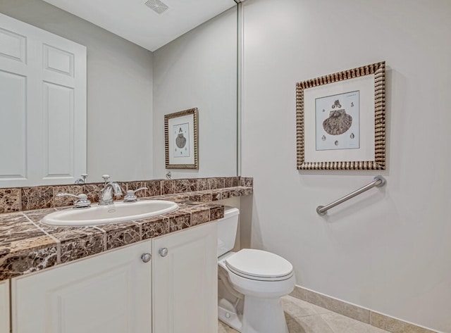 bathroom with vanity, tile patterned flooring, and toilet