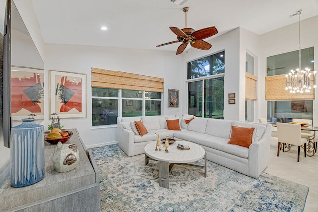 living room with lofted ceiling and ceiling fan with notable chandelier