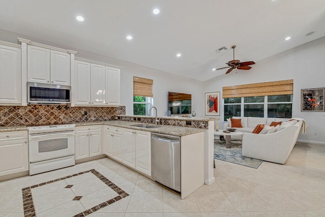 kitchen featuring ceiling fan, vaulted ceiling, sink, stainless steel appliances, and white cabinets