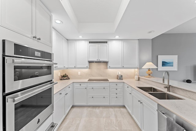 kitchen with white cabinetry, sink, stainless steel appliances, and light stone counters