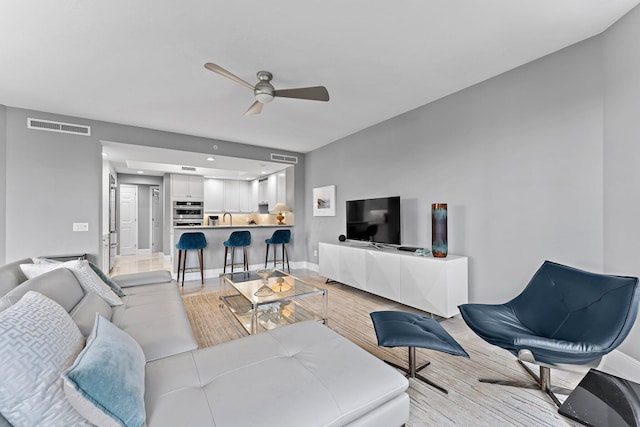 living room with ceiling fan and sink