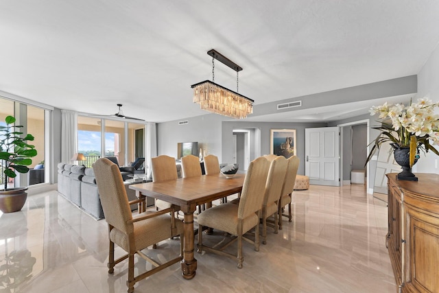 dining area with ceiling fan with notable chandelier