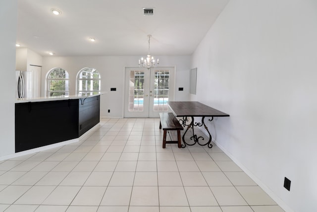 kitchen featuring french doors, stainless steel fridge, a chandelier, pendant lighting, and light tile patterned flooring