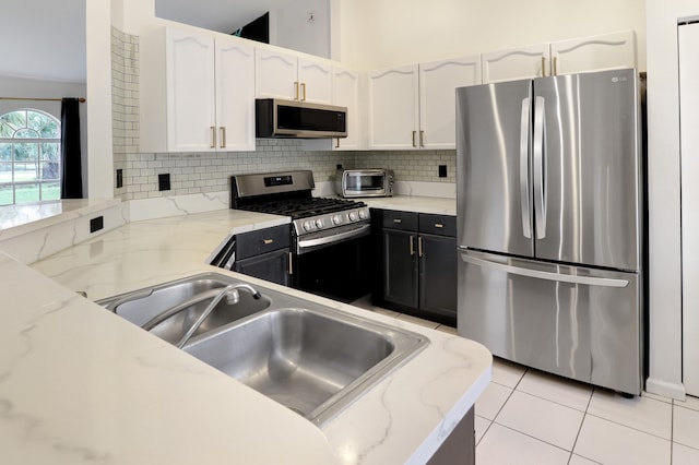 kitchen featuring white cabinets, light stone countertops, and appliances with stainless steel finishes