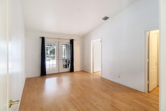 unfurnished room featuring light hardwood / wood-style floors, lofted ceiling, and french doors