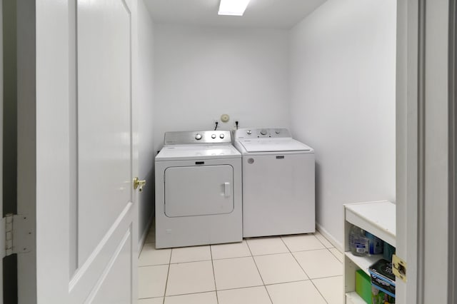 laundry area featuring light tile patterned flooring and washing machine and clothes dryer