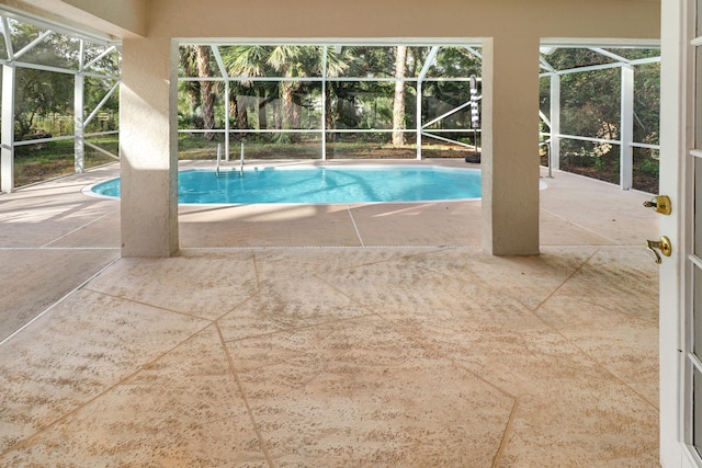 view of swimming pool featuring a lanai and a patio area