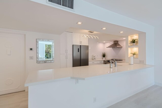 kitchen with white cabinetry, sink, light wood-type flooring, and appliances with stainless steel finishes