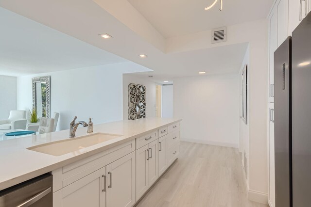 kitchen with white cabinetry, wall chimney exhaust hood, backsplash, kitchen peninsula, and appliances with stainless steel finishes