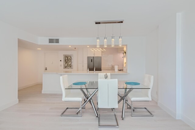 dining space with sink and light wood-type flooring