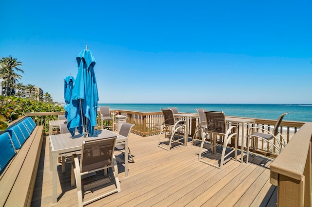 wooden deck with a view of the beach and a water view