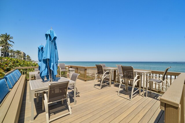 wooden deck featuring a water view and a view of the beach