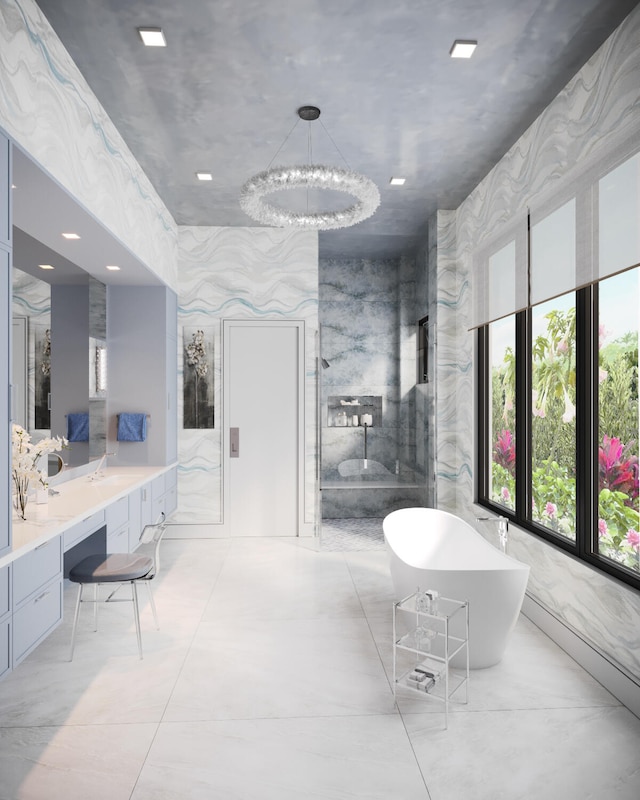 bathroom featuring a notable chandelier, vanity, and separate shower and tub