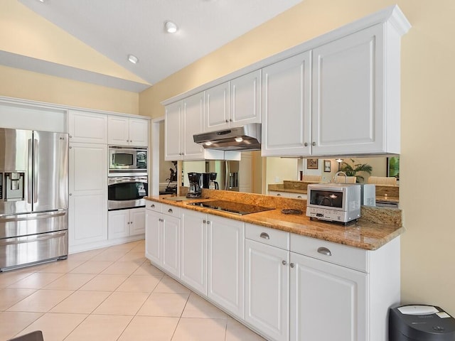 kitchen with light tile patterned floors, white cabinetry, stainless steel appliances, light stone countertops, and vaulted ceiling