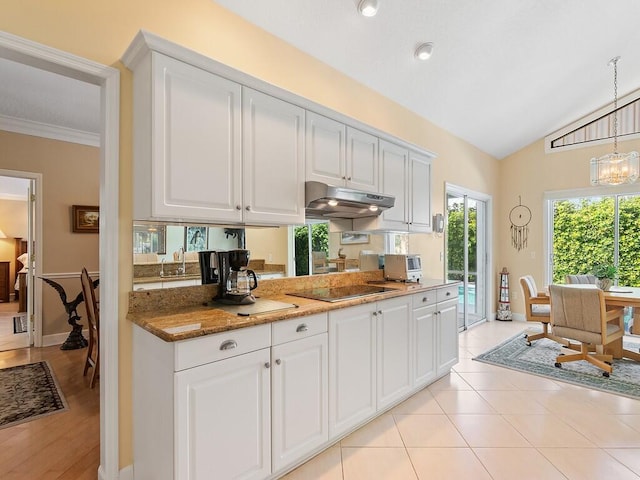 kitchen featuring black electric cooktop, decorative light fixtures, vaulted ceiling, and white cabinets