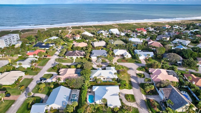 bird's eye view with a water view and a beach view