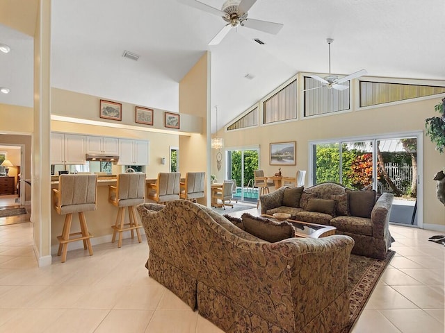 living room with ceiling fan, a wealth of natural light, high vaulted ceiling, and light tile patterned flooring