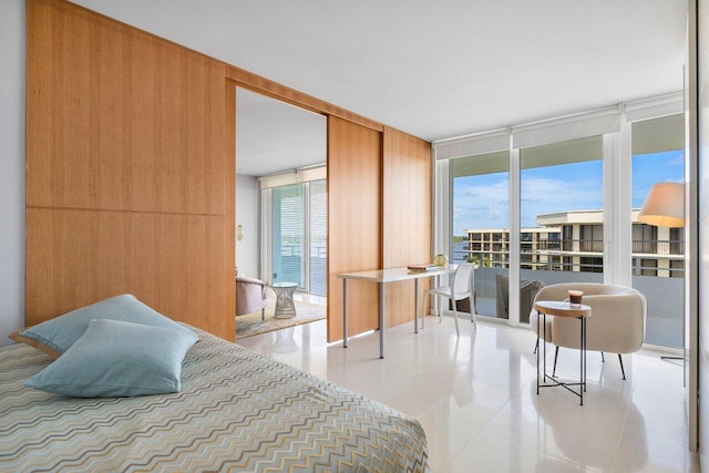 bedroom with light tile patterned flooring, a wall of windows, wood walls, and multiple windows