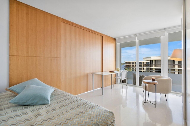 tiled bedroom featuring expansive windows and wooden walls