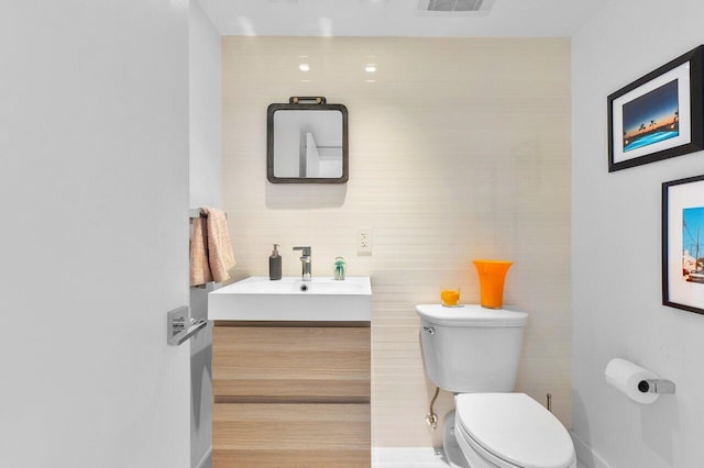 bathroom with wood-type flooring, vanity, and toilet