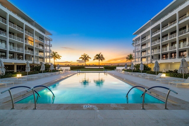 pool at dusk featuring a patio