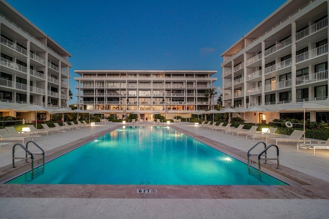 pool at dusk featuring a patio area