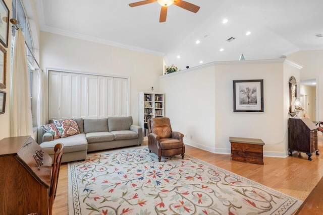 living room featuring light wood-type flooring, lofted ceiling, ornamental molding, and ceiling fan