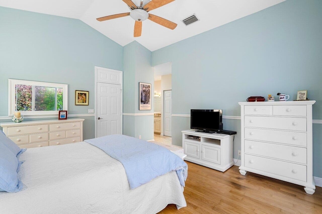 bedroom with ceiling fan, light hardwood / wood-style flooring, ensuite bath, and lofted ceiling