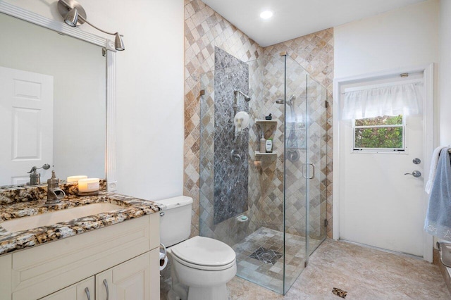 bathroom featuring an enclosed shower, vanity, and toilet