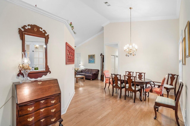 dining space with crown molding, vaulted ceiling, light hardwood / wood-style flooring, and a notable chandelier