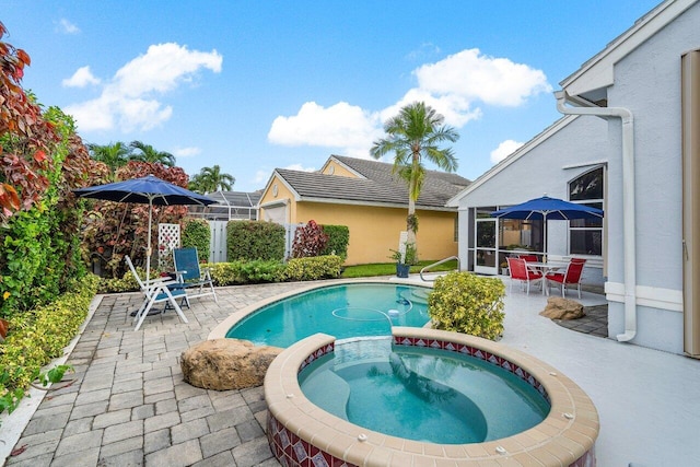 view of swimming pool with an in ground hot tub, a patio area, and glass enclosure