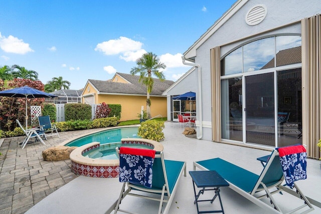 view of pool featuring a lanai, an in ground hot tub, and a patio area