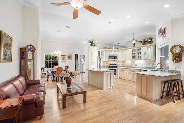 kitchen with pendant lighting, sink, cream cabinetry, appliances with stainless steel finishes, and light wood-type flooring