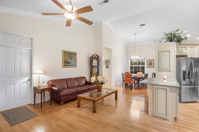 living room with ceiling fan with notable chandelier, light wood-type flooring, ornamental molding, and high vaulted ceiling