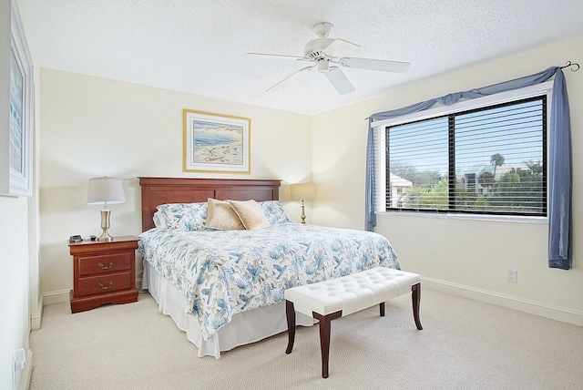 bedroom with light carpet, ceiling fan, and a textured ceiling