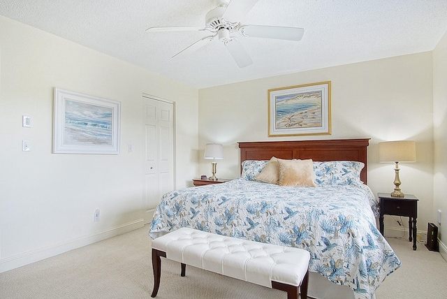 carpeted bedroom with ceiling fan, a textured ceiling, and a closet