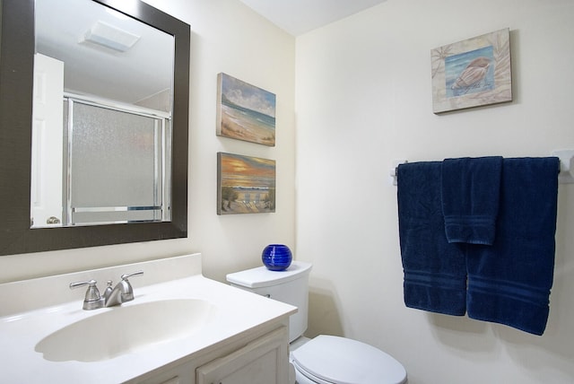 bathroom featuring walk in shower, vanity, and toilet